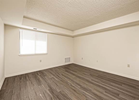 A room with a window and wooden flooring.
