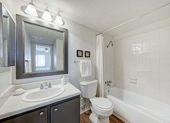A white bathroom with a sink, toilet, and bathtub.