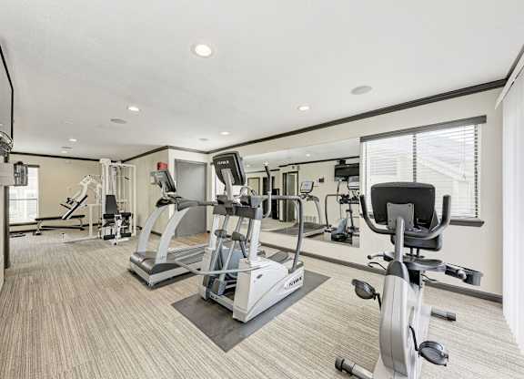 A spacious home gym with a variety of exercise equipment.