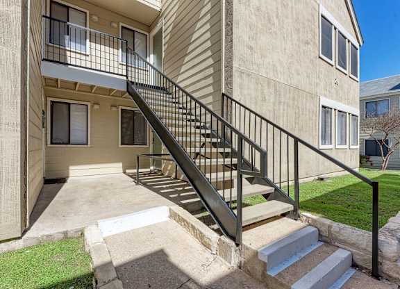 A concrete building with a black metal staircase.