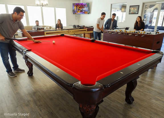 A man is about to hit a pool ball with a cue stick.