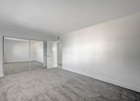 A room with a carpeted floor and a sliding glass door.