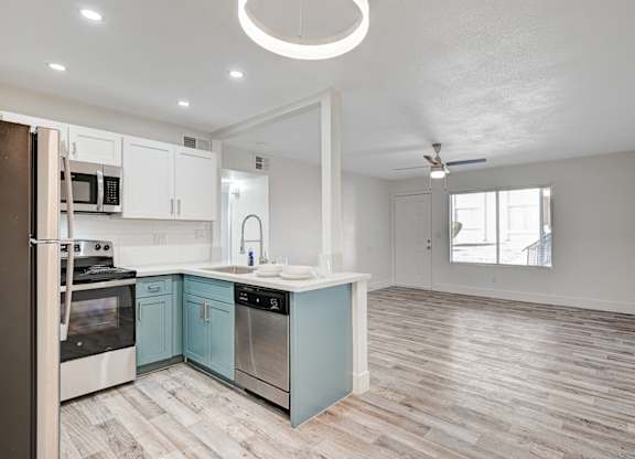 A kitchen with a refrigerator, oven, and sink.