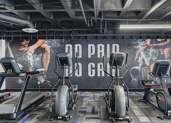 A gym with a sign that says "No Paid Gym" and exercise equipment.