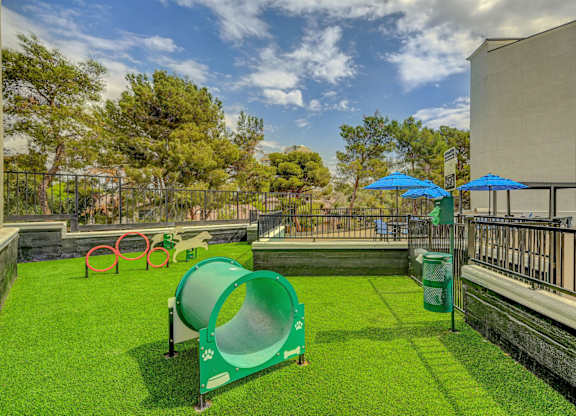 A playground with a green slide and red and green play equipment.