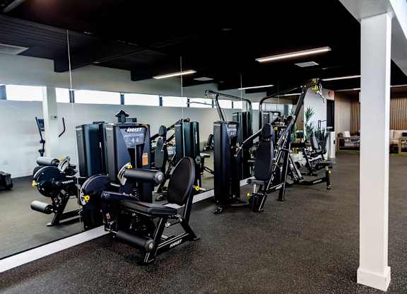 A gym with a variety of equipment including a leg press machine.