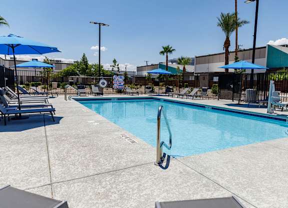 A pool with a diving board and sun loungers.