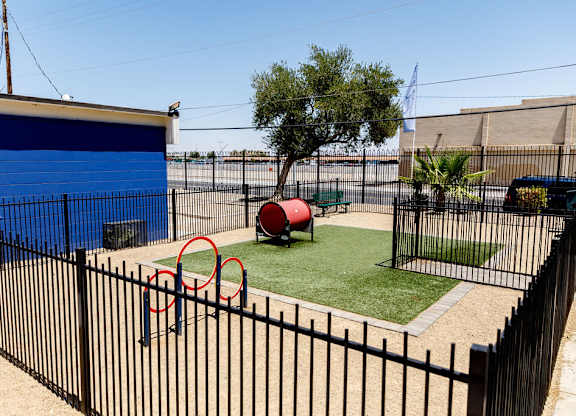 A playground with a red tire swing set and a blue wall.