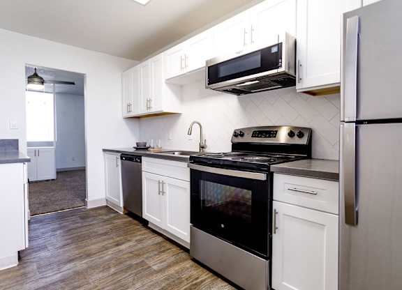 A kitchen with white cabinets and a black stove top oven.