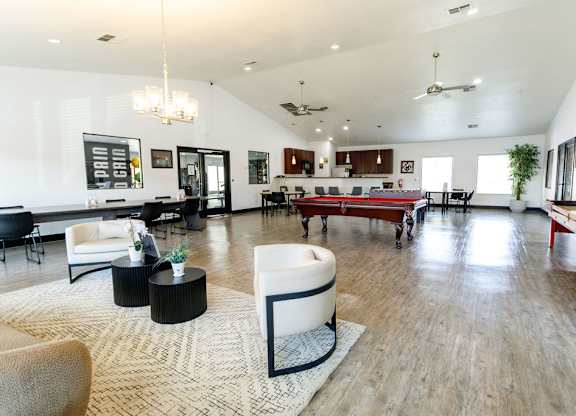 A spacious living room with a variety of furniture and a large rug.