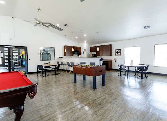 A room with a pool table and a billiard table.