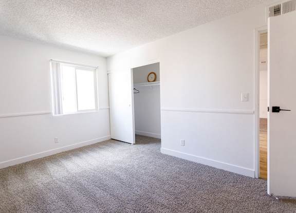 A room with a carpeted floor and a white door.