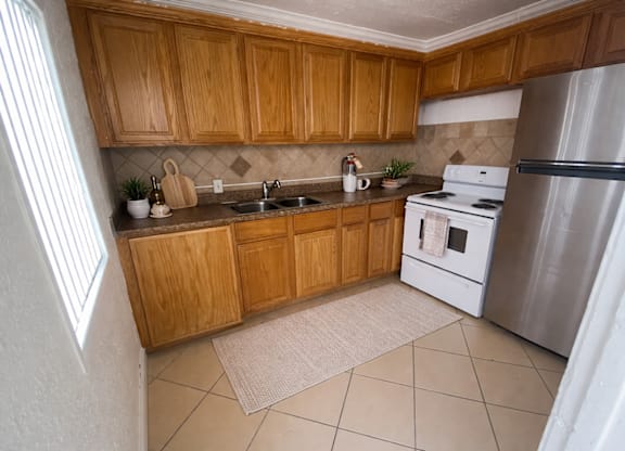 A kitchen with wooden cabinets and a white refrigerator.