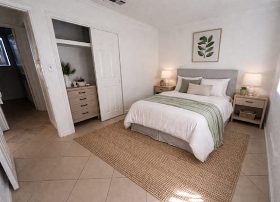 A bedroom with a bed, nightstands, and a rug.