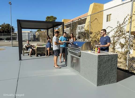 A group of people are gathered around a barbecue grill in a park-like setting.