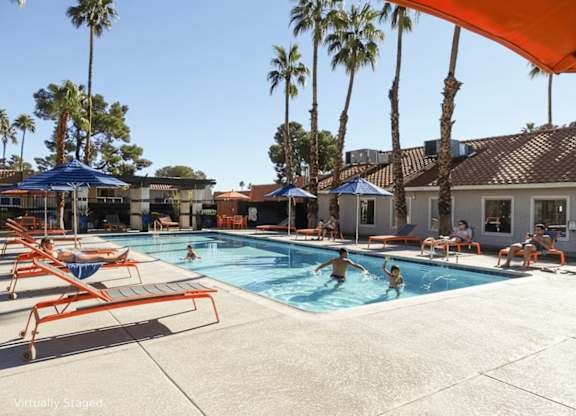 A group of people are enjoying a sunny day at the pool.