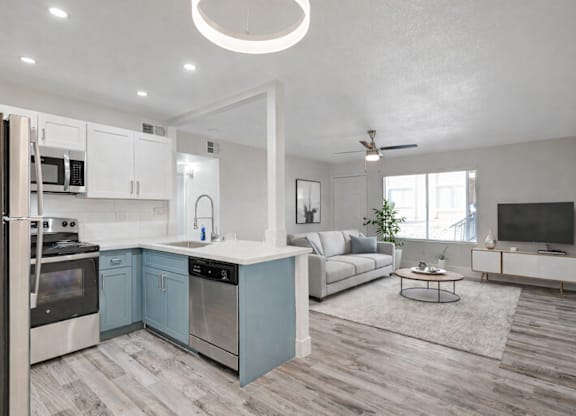 A modern kitchen with a refrigerator, oven, and microwave.
