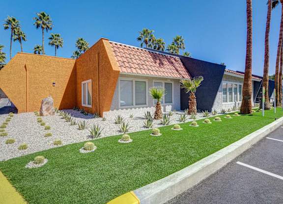 A house with a red tile roof and a yellow front yard.