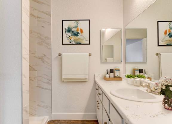 A bathroom with a marble wall and a white sink.