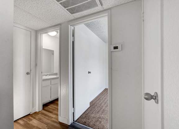 A hallway with a white door and a brown carpet.
