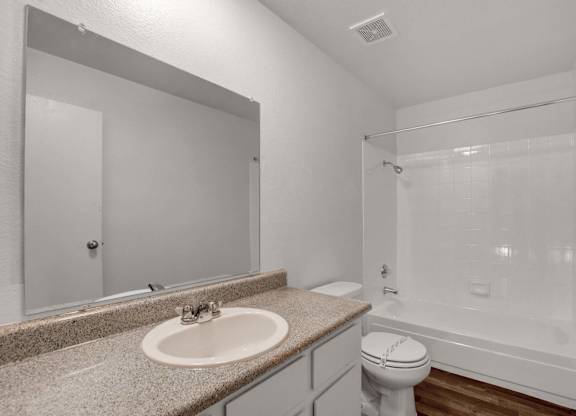 A bathroom with a sink, toilet, and bathtub.