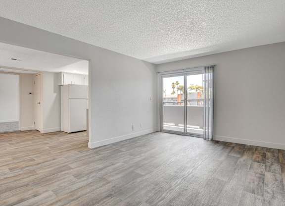 A room with a sliding glass door leading to a balcony.