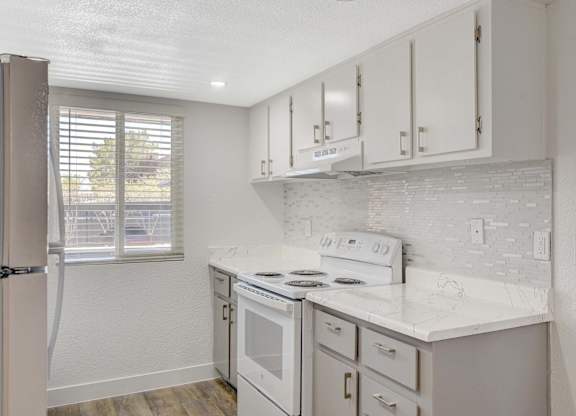 A kitchen with white appliances and cabinets.