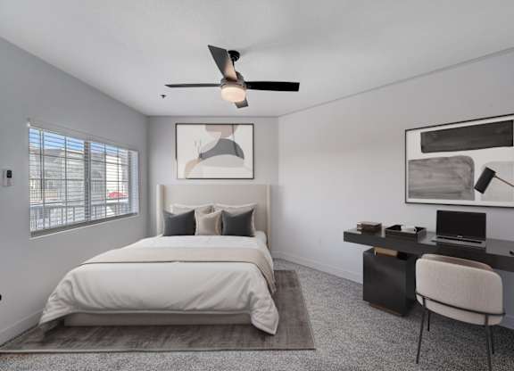 A bedroom with a bed, desk, and chair.