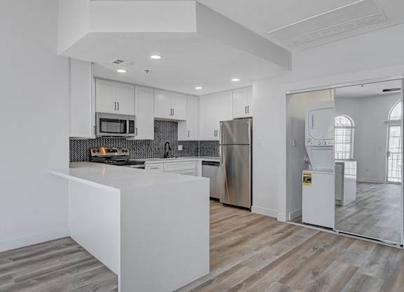 A modern kitchen with stainless steel appliances and white cabinetry.