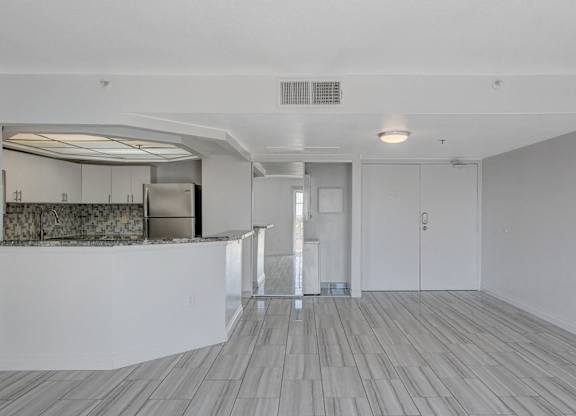 A room with a bar area and a kitchenette.