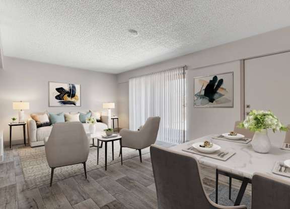 A dining room with a table set for two and a couch with pillows in the background.