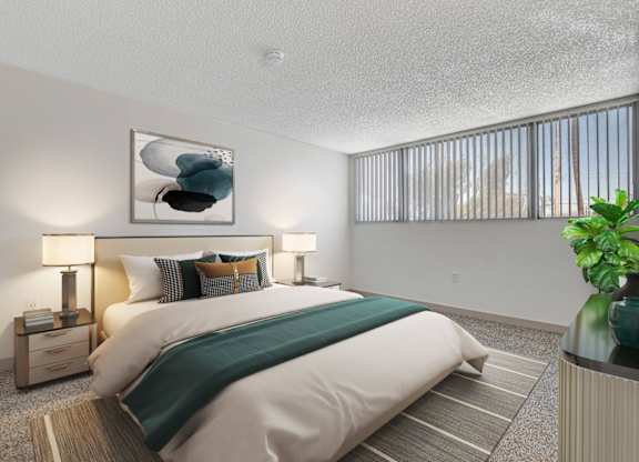 A bedroom with a large bed and a painting on the wall.