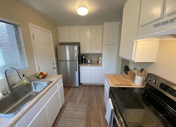 A kitchen with white cabinets and a black stove top oven.