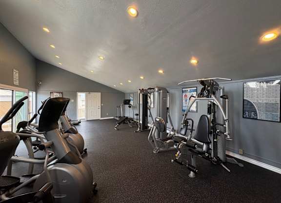 A gym with treadmills, elliptical machines, and other exercise equipment.