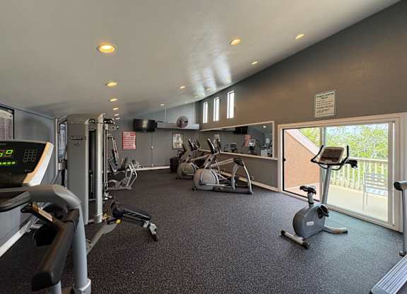 A gym with treadmills, elliptical machines, and other exercise equipment.