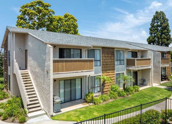 A modern two-story apartment building with a staircase leading to the entrance.