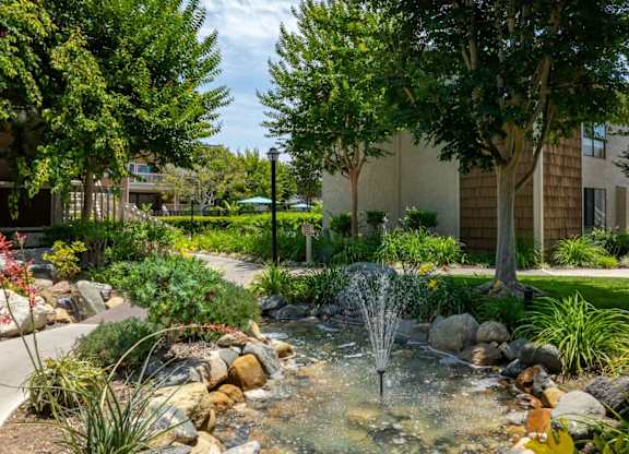 A garden with a fountain in the middle of it.