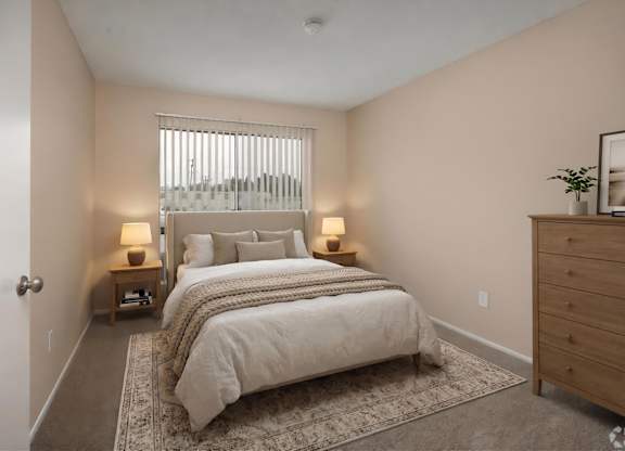 A bedroom with a large bed and two lamps.