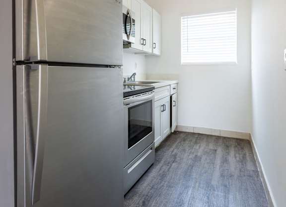 A kitchen with a stainless steel refrigerator and oven.