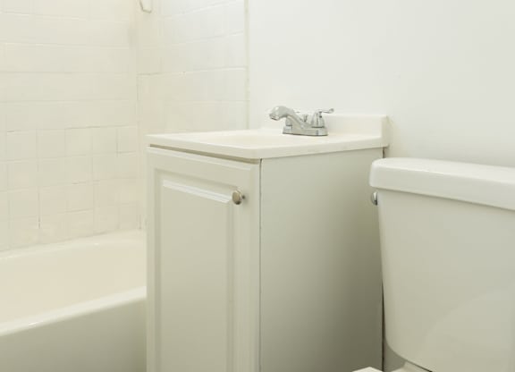 A white toilet sits next to a white sink in a bathroom.