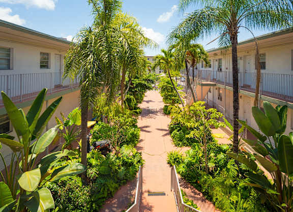 A pathway leads through a lush green courtyard.