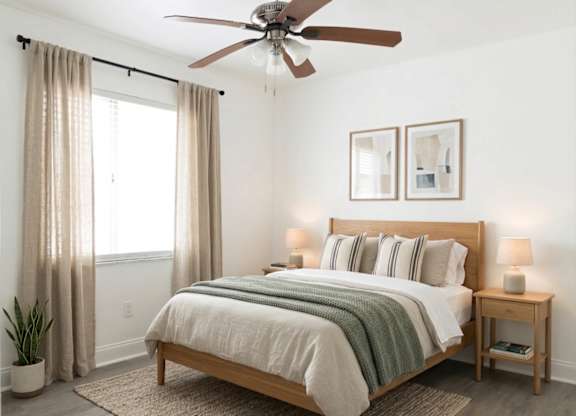 A bedroom with a large bed and a ceiling fan.