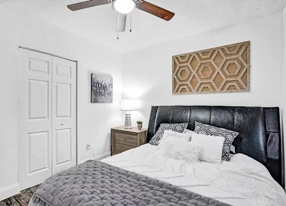A bedroom with a black headboard and a white bedspread.