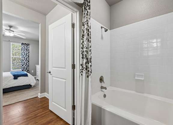 A white bathroom with a white tub and a white door.