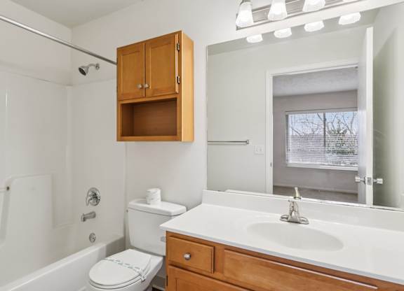 A white bathroom with a toilet, sink, and shower.