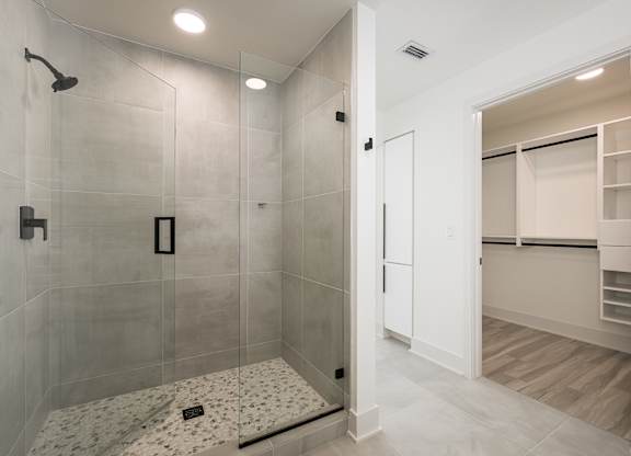 Frameless walk-in showers with stone flooring