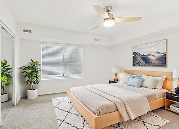 A bedroom with a large bed and a ceiling fan.