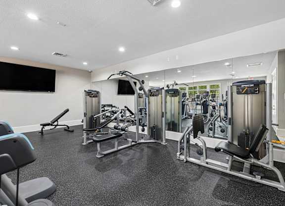 A well-equipped gym with various machines and weightlifting equipment.