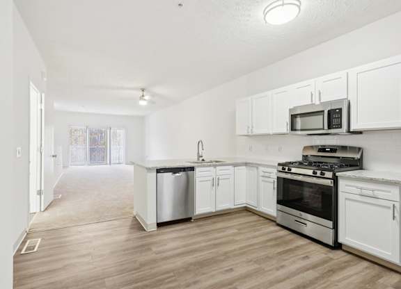 A kitchen with white cabinets and stainless steel appliances.
