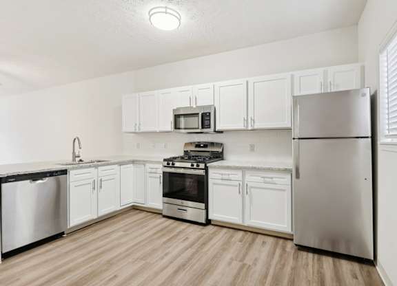 A kitchen with white cabinets and stainless steel appliances.